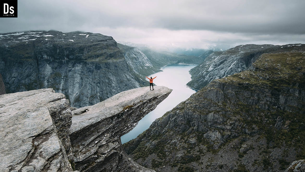 Not long ago, Denys Dynamics envisioned his travels as a series of dreams, filled with vivid images and distant horizons. He imagined himself racing along picturesque roads, surrounded by majestic mountains and sparkling fjords, stopping to breathe in the fresh air and feel nature's energy invigorate him.  And now, here he is, at the pinnacle of the world—on Trolltunga, the stunning cliff in Norway. This is a place where clouds kiss the peaks, and horizons unfold into infinity. From the height at which he stands, a breathtaking panorama opens up, captivating and inspiring him. The indescribable beauty of the surrounding world fills his soul, and he feels his heart beating in harmony with the rhythms of nature.  On Trolltunga, Denys feels as if he’s in a fairy tale, where every stone and every path tells its own story. Here, amidst towering cliffs and lush valleys, he realizes that his dreams of travel have become a reality. He is not merely a traveler; he is an explorer, uncovering new horizons not only in the world but also within himself.  Every step he takes in this magical place fills him with new thoughts and ideas. He understands that these moments at the top of the world are not just about stunning views; they are a source of inspiration for future projects that could change lives. On Trolltunga, Denys finds not only physical elevation but also inner harmony, which will empower him to continue his journey, rich with discoveries and creativity.